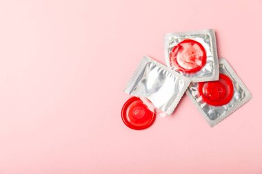 Renkli arka planda prezervatifler. Paketlemede renkli meyve temalı prezervatifler. Güvenli seks konsepti. Doğum kontrol hapı. Farklı doğum kontrol yöntemleri. AİDS önleme. Dünya AIDS Günü. Cinsel sağlık.