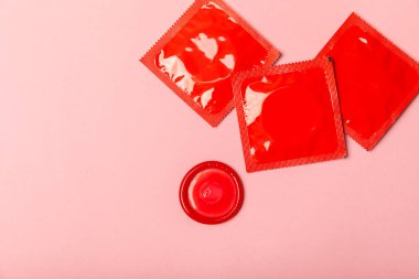 Renkli arka planda prezervatifler. Paketlemede renkli meyve temalı prezervatifler. Güvenli seks konsepti. Doğum kontrol hapı. Farklı doğum kontrol yöntemleri. AİDS önleme. Dünya AIDS Günü. Cinsel sağlık.