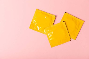 Renkli arka planda prezervatifler. Paketlemede renkli meyve temalı prezervatifler. Güvenli seks konsepti. Doğum kontrol hapı. Farklı doğum kontrol yöntemleri. AİDS önleme. Dünya AIDS Günü. Cinsel sağlık.