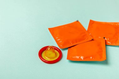 Renkli arka planda prezervatifler. Paketlemede renkli meyve temalı prezervatifler. Güvenli seks konsepti. Doğum kontrol hapı. Farklı doğum kontrol yöntemleri. AİDS önleme. Dünya AIDS Günü. Cinsel sağlık.