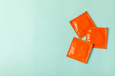 Renkli arka planda prezervatifler. Paketlemede renkli meyve temalı prezervatifler. Güvenli seks konsepti. Doğum kontrol hapı. Farklı doğum kontrol yöntemleri. AİDS önleme. Dünya AIDS Günü. Cinsel sağlık.