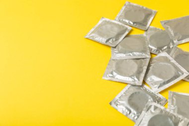 Renkli arka planda prezervatifler. Paketlemede renkli meyve temalı prezervatifler. Güvenli seks konsepti. Doğum kontrol hapı. Farklı doğum kontrol yöntemleri. AİDS önleme. Dünya AIDS Günü. Cinsel sağlık.