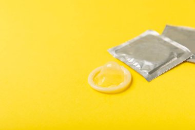 Renkli arka planda prezervatifler. Paketlemede renkli meyve temalı prezervatifler. Güvenli seks konsepti. Doğum kontrol hapı. Farklı doğum kontrol yöntemleri. AİDS önleme. Dünya AIDS Günü. Cinsel sağlık.