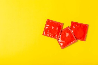 Renkli arka planda prezervatifler. Paketlemede renkli meyve temalı prezervatifler. Güvenli seks konsepti. Doğum kontrol hapı. Farklı doğum kontrol yöntemleri. AİDS önleme. Dünya AIDS Günü. Cinsel sağlık.