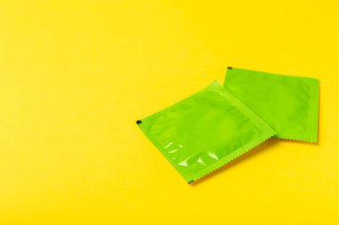 Renkli arka planda prezervatifler. Paketlemede renkli meyve temalı prezervatifler. Güvenli seks konsepti. Doğum kontrol hapı. Farklı doğum kontrol yöntemleri. AİDS önleme. Dünya AIDS Günü. Cinsel sağlık.