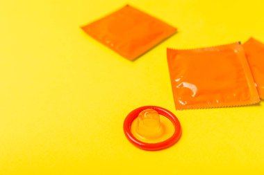 Renkli arka planda prezervatifler. Paketlemede renkli meyve temalı prezervatifler. Güvenli seks konsepti. Doğum kontrol hapı. Farklı doğum kontrol yöntemleri. AİDS önleme. Dünya AIDS Günü. Cinsel sağlık.