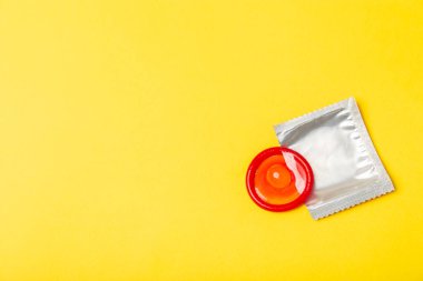 Renkli arka planda prezervatifler. Paketlemede renkli meyve temalı prezervatifler. Güvenli seks konsepti. Doğum kontrol hapı. Farklı doğum kontrol yöntemleri. AİDS önleme. Dünya AIDS Günü. Cinsel sağlık.