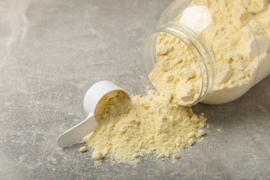 Protein powder. A spoonful of protein powder on a table. Different flavors of whey protein powder. Sports nutrition concept. Gym. Amino acid food supplement, creatine powder. Copy space.