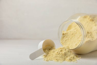 Protein powder. A spoonful of protein powder on a table. Different flavors of whey protein powder. Sports nutrition concept. Gym. Amino acid food supplement, creatine powder. Copy space.