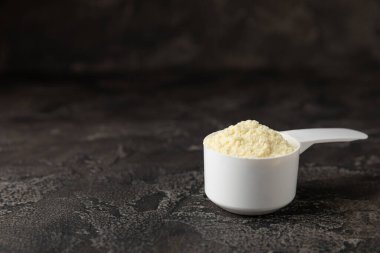 Protein powder. A spoonful of protein powder on a table. Different flavors of whey protein powder. Sports nutrition concept. Gym. Amino acid food supplement, creatine powder. Copy space.