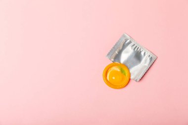 Renkli arka planda prezervatifler. Paketlemede renkli meyve temalı prezervatifler. Güvenli seks konsepti. Doğum kontrol hapı. Farklı doğum kontrol yöntemleri. AİDS önleme. Dünya AIDS Günü. Cinsel sağlık.