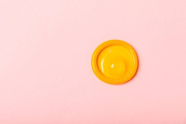 Renkli arka planda prezervatifler. Paketlemede renkli meyve temalı prezervatifler. Güvenli seks konsepti. Doğum kontrol hapı. Farklı doğum kontrol yöntemleri. AİDS önleme. Dünya AIDS Günü. Cinsel sağlık.