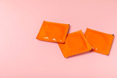 Renkli arka planda prezervatifler. Paketlemede renkli meyve temalı prezervatifler. Güvenli seks konsepti. Doğum kontrol hapı. Farklı doğum kontrol yöntemleri. AİDS önleme. Dünya AIDS Günü. Cinsel sağlık.