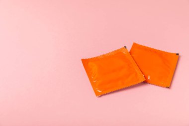 Renkli arka planda prezervatifler. Paketlemede renkli meyve temalı prezervatifler. Güvenli seks konsepti. Doğum kontrol hapı. Farklı doğum kontrol yöntemleri. AİDS önleme. Dünya AIDS Günü. Cinsel sağlık.