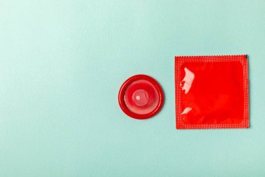 Renkli arka planda prezervatifler. Paketlemede renkli meyve temalı prezervatifler. Güvenli seks konsepti. Doğum kontrol hapı. Farklı doğum kontrol yöntemleri. AİDS önleme. Dünya AIDS Günü. Cinsel sağlık.