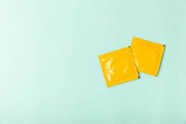 Renkli arka planda prezervatifler. Paketlemede renkli meyve temalı prezervatifler. Güvenli seks konsepti. Doğum kontrol hapı. Farklı doğum kontrol yöntemleri. AİDS önleme. Dünya AIDS Günü. Cinsel sağlık.