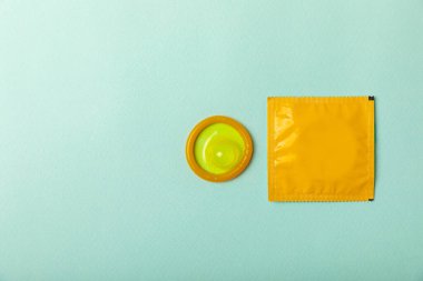 Renkli arka planda prezervatifler. Paketlemede renkli meyve temalı prezervatifler. Güvenli seks konsepti. Doğum kontrol hapı. Farklı doğum kontrol yöntemleri. AİDS önleme. Dünya AIDS Günü. Cinsel sağlık.