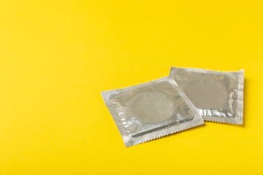 Renkli arka planda prezervatifler. Paketlemede renkli meyve temalı prezervatifler. Güvenli seks konsepti. Doğum kontrol hapı. Farklı doğum kontrol yöntemleri. AİDS önleme. Dünya AIDS Günü. Cinsel sağlık.