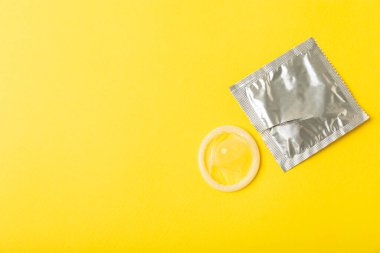 Renkli arka planda prezervatifler. Paketlemede renkli meyve temalı prezervatifler. Güvenli seks konsepti. Doğum kontrol hapı. Farklı doğum kontrol yöntemleri. AİDS önleme. Dünya AIDS Günü. Cinsel sağlık.