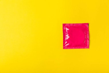 Renkli arka planda prezervatifler. Paketlemede renkli meyve temalı prezervatifler. Güvenli seks konsepti. Doğum kontrol hapı. Farklı doğum kontrol yöntemleri. AİDS önleme. Dünya AIDS Günü. Cinsel sağlık.