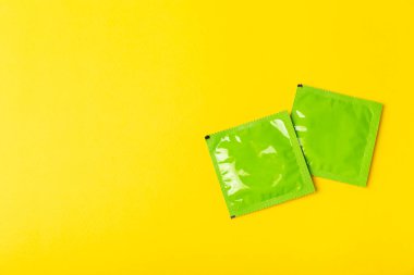 Renkli arka planda prezervatifler. Paketlemede renkli meyve temalı prezervatifler. Güvenli seks konsepti. Doğum kontrol hapı. Farklı doğum kontrol yöntemleri. AİDS önleme. Dünya AIDS Günü. Cinsel sağlık.