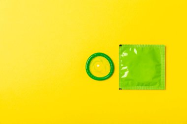 Renkli arka planda prezervatifler. Paketlemede renkli meyve temalı prezervatifler. Güvenli seks konsepti. Doğum kontrol hapı. Farklı doğum kontrol yöntemleri. AİDS önleme. Dünya AIDS Günü. Cinsel sağlık.