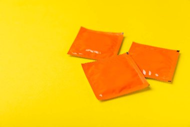 Renkli arka planda prezervatifler. Paketlemede renkli meyve temalı prezervatifler. Güvenli seks konsepti. Doğum kontrol hapı. Farklı doğum kontrol yöntemleri. AİDS önleme. Dünya AIDS Günü. Cinsel sağlık.