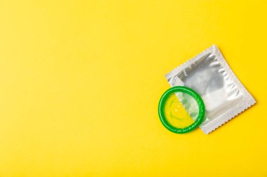 Renkli arka planda prezervatifler. Paketlemede renkli meyve temalı prezervatifler. Güvenli seks konsepti. Doğum kontrol hapı. Farklı doğum kontrol yöntemleri. AİDS önleme. Dünya AIDS Günü. Cinsel sağlık.