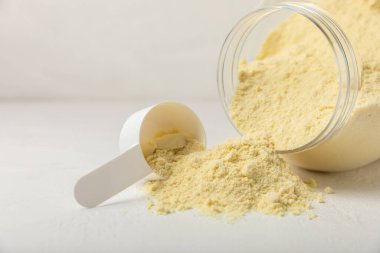 Protein powder. A spoonful of protein powder on a table. Different flavors of whey protein powder. Sports nutrition concept. Gym. Amino acid food supplement, creatine powder. Copy space.