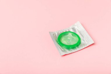 Renkli arka planda prezervatifler. Paketlemede renkli meyve temalı prezervatifler. Güvenli seks konsepti. Doğum kontrol hapı. Farklı doğum kontrol yöntemleri. AİDS önleme. Dünya AIDS Günü. Cinsel sağlık.