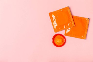 Renkli arka planda prezervatifler. Paketlemede renkli meyve temalı prezervatifler. Güvenli seks konsepti. Doğum kontrol hapı. Farklı doğum kontrol yöntemleri. AİDS önleme. Dünya AIDS Günü. Cinsel sağlık.