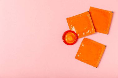 Renkli arka planda prezervatifler. Paketlemede renkli meyve temalı prezervatifler. Güvenli seks konsepti. Doğum kontrol hapı. Farklı doğum kontrol yöntemleri. AİDS önleme. Dünya AIDS Günü. Cinsel sağlık.