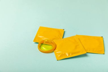 Renkli arka planda prezervatifler. Paketlemede renkli meyve temalı prezervatifler. Güvenli seks konsepti. Doğum kontrol hapı. Farklı doğum kontrol yöntemleri. AİDS önleme. Dünya AIDS Günü. Cinsel sağlık.