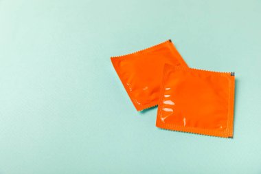 Renkli arka planda prezervatifler. Paketlemede renkli meyve temalı prezervatifler. Güvenli seks konsepti. Doğum kontrol hapı. Farklı doğum kontrol yöntemleri. AİDS önleme. Dünya AIDS Günü. Cinsel sağlık.