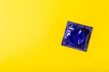 Renkli arka planda prezervatifler. Paketlemede renkli meyve temalı prezervatifler. Güvenli seks konsepti. Doğum kontrol hapı. Farklı doğum kontrol yöntemleri. AİDS önleme. Dünya AIDS Günü. Cinsel sağlık.