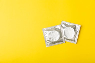 Renkli arka planda prezervatifler. Paketlemede renkli meyve temalı prezervatifler. Güvenli seks konsepti. Doğum kontrol hapı. Farklı doğum kontrol yöntemleri. AİDS önleme. Dünya AIDS Günü. Cinsel sağlık.