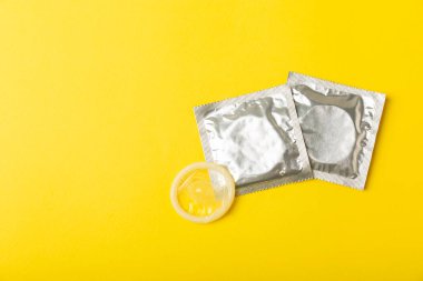 Renkli arka planda prezervatifler. Paketlemede renkli meyve temalı prezervatifler. Güvenli seks konsepti. Doğum kontrol hapı. Farklı doğum kontrol yöntemleri. AİDS önleme. Dünya AIDS Günü. Cinsel sağlık.