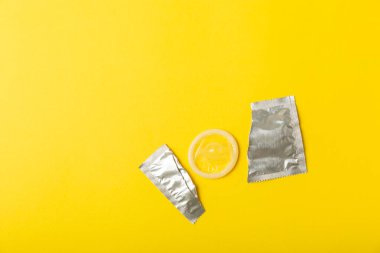 Renkli arka planda prezervatifler. Paketlemede renkli meyve temalı prezervatifler. Güvenli seks konsepti. Doğum kontrol hapı. Farklı doğum kontrol yöntemleri. AİDS önleme. Dünya AIDS Günü. Cinsel sağlık.