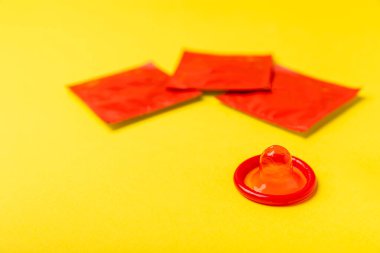 Renkli arka planda prezervatifler. Paketlemede renkli meyve temalı prezervatifler. Güvenli seks konsepti. Doğum kontrol hapı. Farklı doğum kontrol yöntemleri. AİDS önleme. Dünya AIDS Günü. Cinsel sağlık.