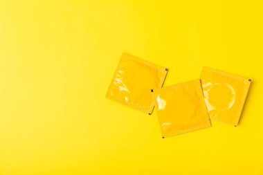 Renkli arka planda prezervatifler. Paketlemede renkli meyve temalı prezervatifler. Güvenli seks konsepti. Doğum kontrol hapı. Farklı doğum kontrol yöntemleri. AİDS önleme. Dünya AIDS Günü. Cinsel sağlık.