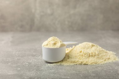 Protein powder. A spoonful of protein powder on a table. Different flavors of whey protein powder. Sports nutrition concept. Gym. Amino acid food supplement, creatine powder. Copy space.