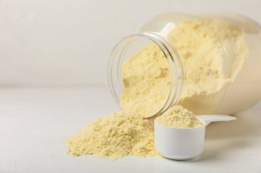 Protein powder. A spoonful of protein powder on a table. Different flavors of whey protein powder. Sports nutrition concept. Gym. Amino acid food supplement, creatine powder. Copy space.