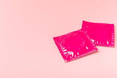 Renkli arka planda prezervatifler. Paketlemede renkli meyve temalı prezervatifler. Güvenli seks konsepti. Doğum kontrol hapı. Farklı doğum kontrol yöntemleri. AİDS önleme. Dünya AIDS Günü. Cinsel sağlık.