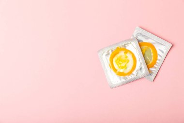 Renkli arka planda prezervatifler. Paketlemede renkli meyve temalı prezervatifler. Güvenli seks konsepti. Doğum kontrol hapı. Farklı doğum kontrol yöntemleri. AİDS önleme. Dünya AIDS Günü. Cinsel sağlık.