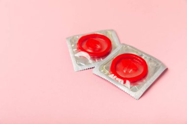 Renkli arka planda prezervatifler. Paketlemede renkli meyve temalı prezervatifler. Güvenli seks konsepti. Doğum kontrol hapı. Farklı doğum kontrol yöntemleri. AİDS önleme. Dünya AIDS Günü. Cinsel sağlık.