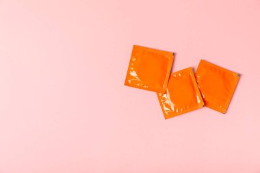 Renkli arka planda prezervatifler. Paketlemede renkli meyve temalı prezervatifler. Güvenli seks konsepti. Doğum kontrol hapı. Farklı doğum kontrol yöntemleri. AİDS önleme. Dünya AIDS Günü. Cinsel sağlık.