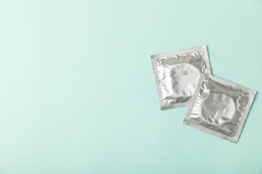 Renkli arka planda prezervatifler. Paketlemede renkli meyve temalı prezervatifler. Güvenli seks konsepti. Doğum kontrol hapı. Farklı doğum kontrol yöntemleri. AİDS önleme. Dünya AIDS Günü. Cinsel sağlık.