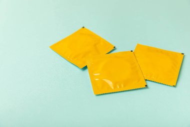 Renkli arka planda prezervatifler. Paketlemede renkli meyve temalı prezervatifler. Güvenli seks konsepti. Doğum kontrol hapı. Farklı doğum kontrol yöntemleri. AİDS önleme. Dünya AIDS Günü. Cinsel sağlık.