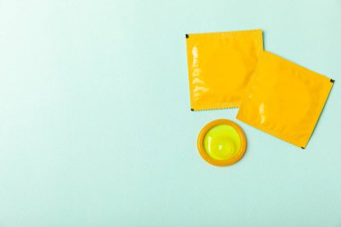 Renkli arka planda prezervatifler. Paketlemede renkli meyve temalı prezervatifler. Güvenli seks konsepti. Doğum kontrol hapı. Farklı doğum kontrol yöntemleri. AİDS önleme. Dünya AIDS Günü. Cinsel sağlık.