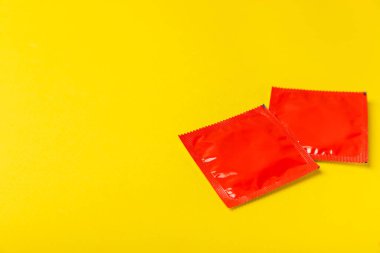 Renkli arka planda prezervatifler. Paketlemede renkli meyve temalı prezervatifler. Güvenli seks konsepti. Doğum kontrol hapı. Farklı doğum kontrol yöntemleri. AİDS önleme. Dünya AIDS Günü. Cinsel sağlık.